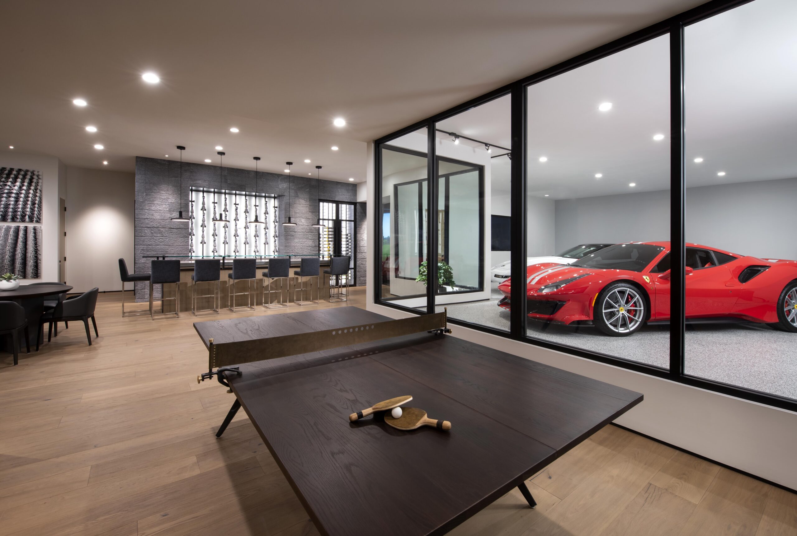 Haven - Car Bar indoor setting with a table tennis set up and two luxurious cars.