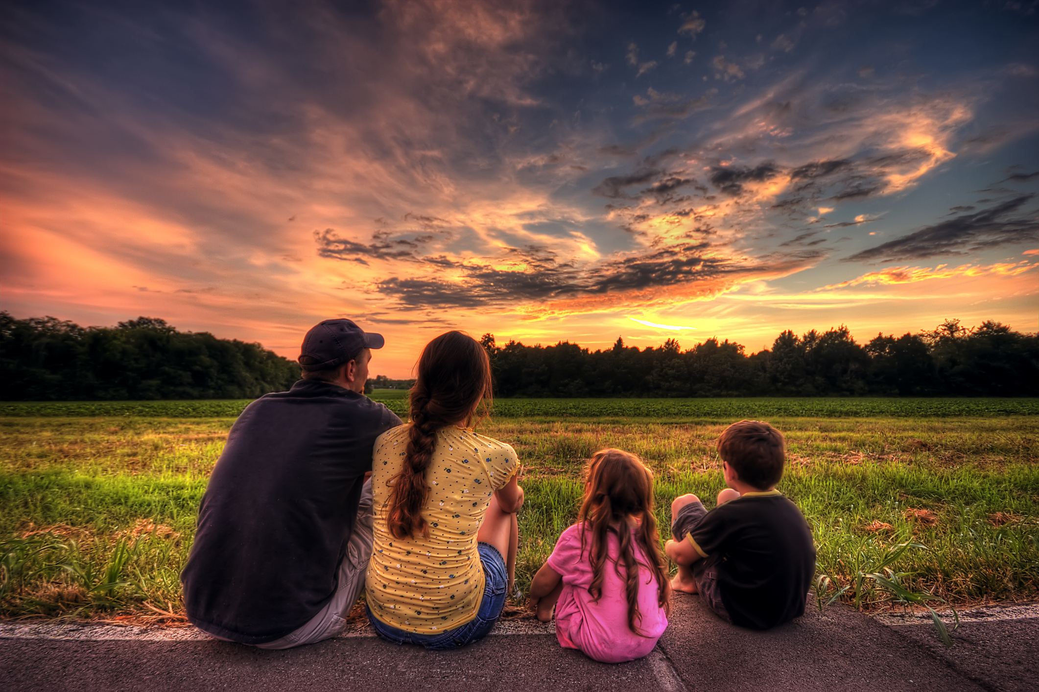 Family Sunset - a family picture in a green field beside the road in sunset.