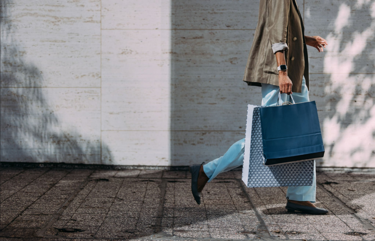 Fashion District - A person walking while holding bags